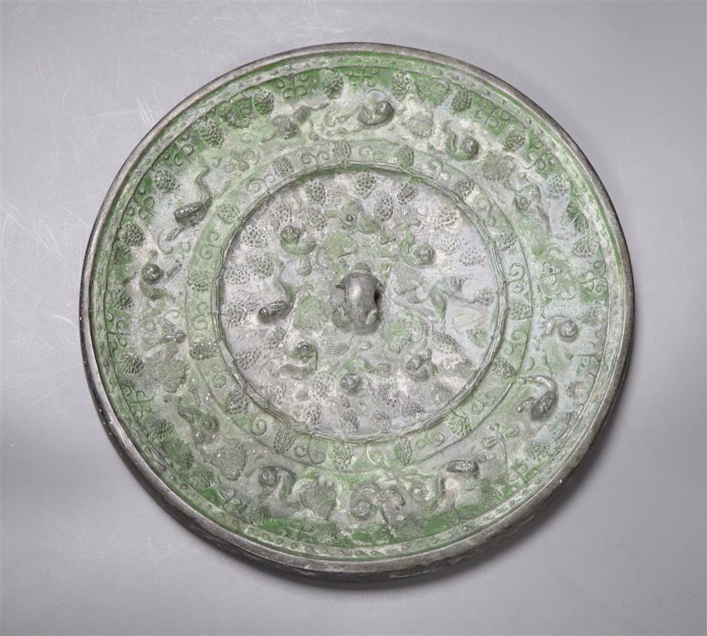 A bronze Chinese squirrel and grape pattern mirror, Tang dynasty or later, diameter 24cm